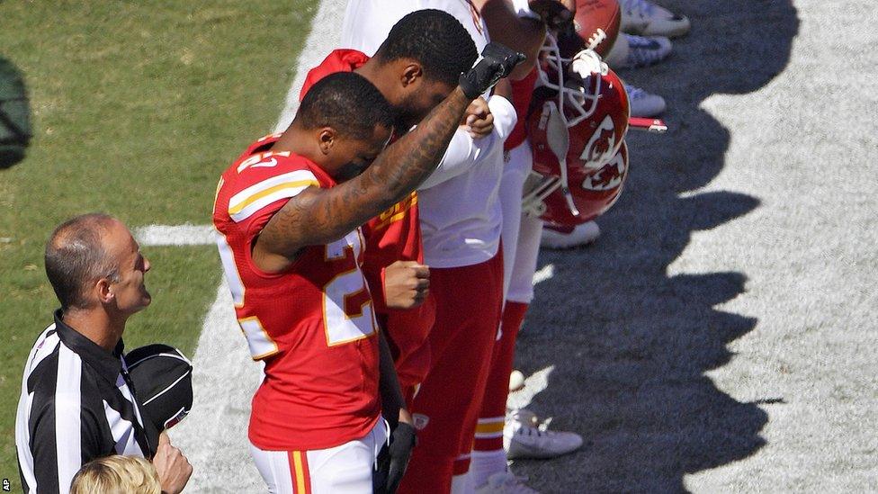 Kansas City Chiefs' Marcus Peters raises his fist in protest