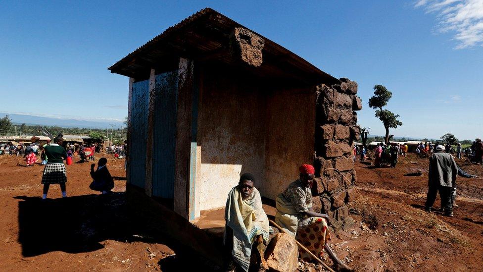 Survivors sit outside their destroyed house after a dam burst, which unleashed water at nearby homes, in Solio town near Nakuru, Kenya on 10 May 2018