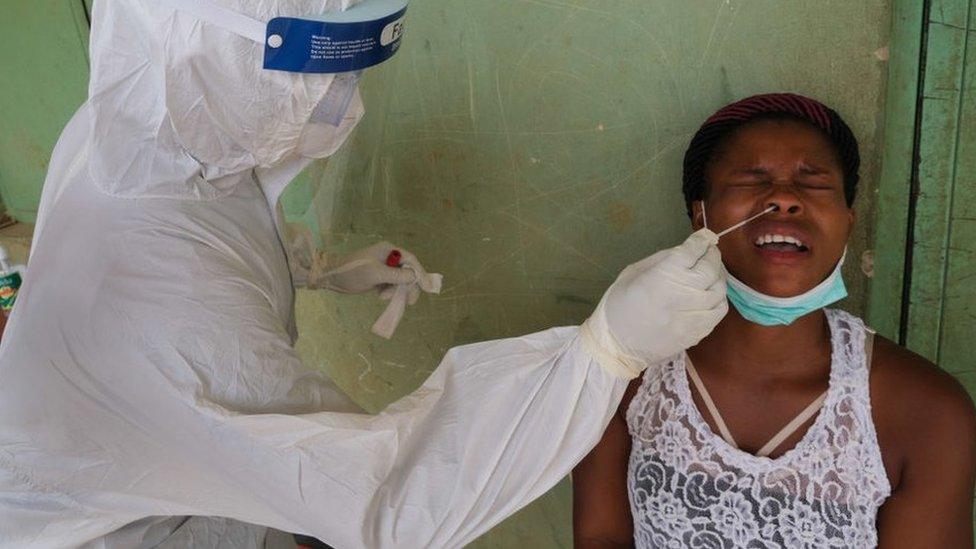 A health worker takes a swab from a woman during a community COVID-19 coronavirus testing campaign in Abuja on April 15, 2020.