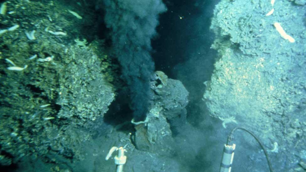 View from a deep sea vehicle of the billowing black "smoke" being emitted by a hydrothermal vent on the ocean floor. Known as a "black smoker", this sulphurous mineral-rich fluid pours out of a sulphur-encrusted mound or chimney.