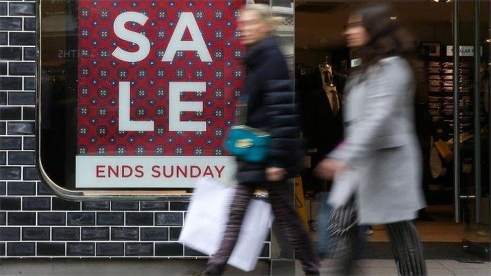 Women walking past a sale sign