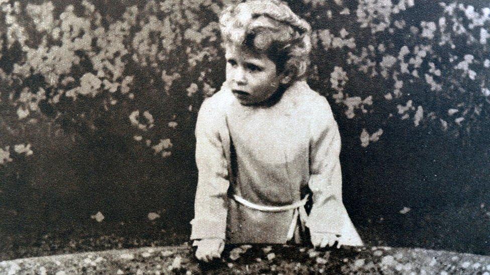 A Young Princess Elizabeth, later Queen Elizabeth II stands on a bridge in the Glamis Castle in Scotland, where both princesses grew up.