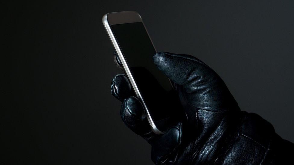 Phone in gloved hand