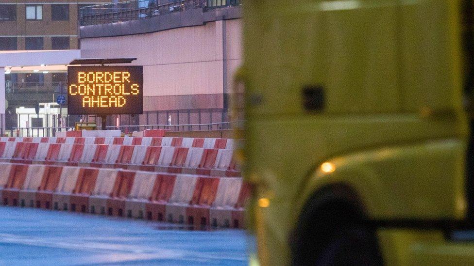 A truck approaches a border control sign.