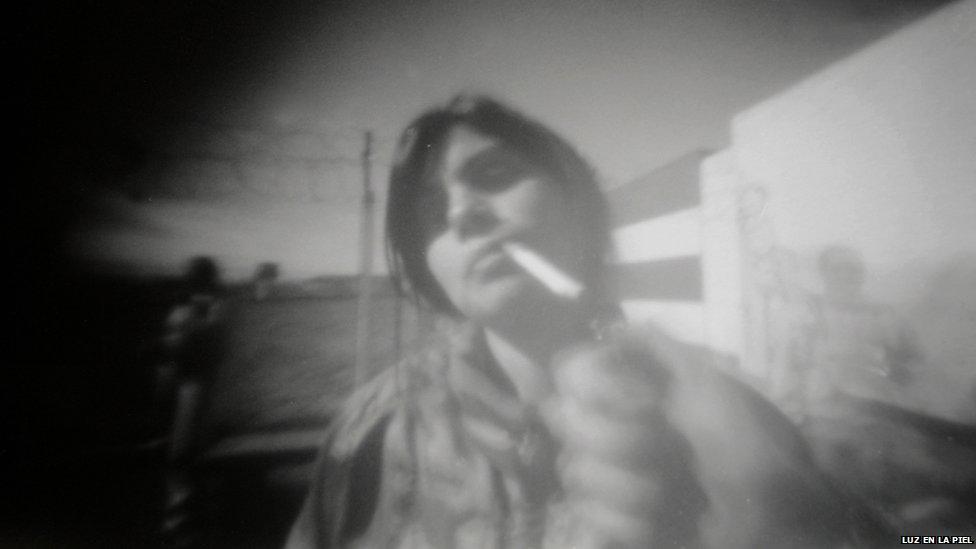 A pinhole photograph of a woman smoking