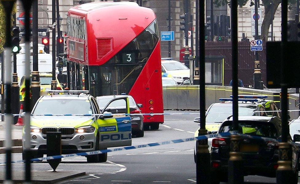 A car that crashed outside the Houses of Parliament surrounded by members of the emergency services in Westminster