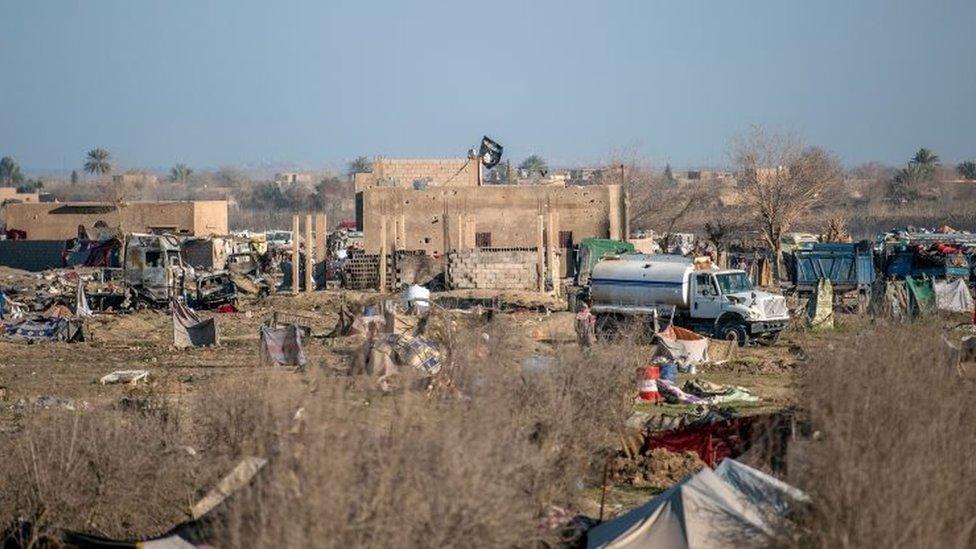 An Islamic State flag is seen on top of a building in the town of Baghuz, in the eastern Syrian province of Deir Ezzor, on 9 March 2019.