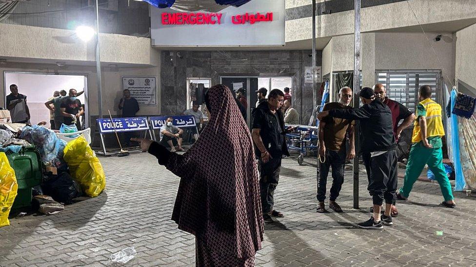 People stand outside the emergency ward of Al-Shifa hospital in Gaza City