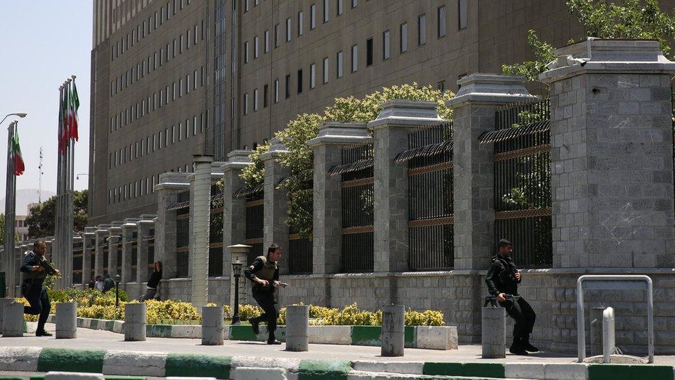 Iranian security personnel run during an attack at the parliament building in Tehran, Iran (7 June 2017)