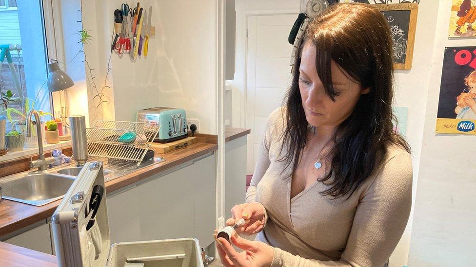 Emily holding a syringe with cannabis oil in