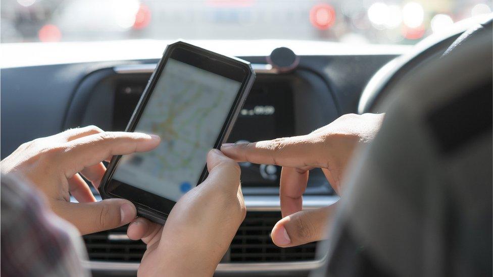 Two people use mapping app in a car