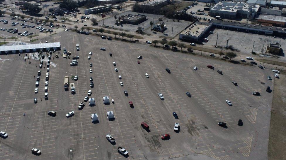 Cars line up to collect cases of water