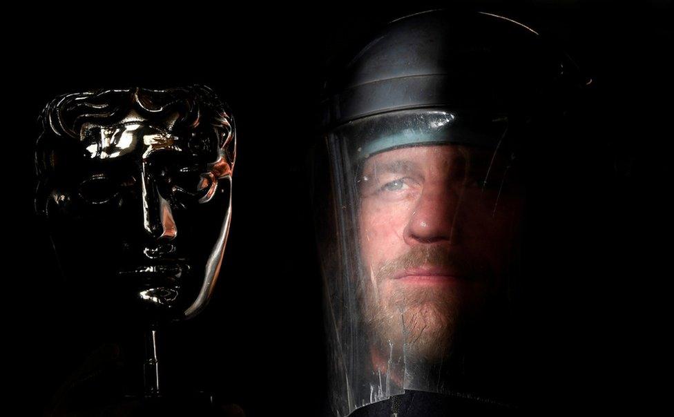 Ray Terry, a furnace man at the foundry where the castings of the iconic British Academy of Film and Television Awards (BAFTA) masks are made, poses with a finished mask, ahead of the annual awards ceremony, London.