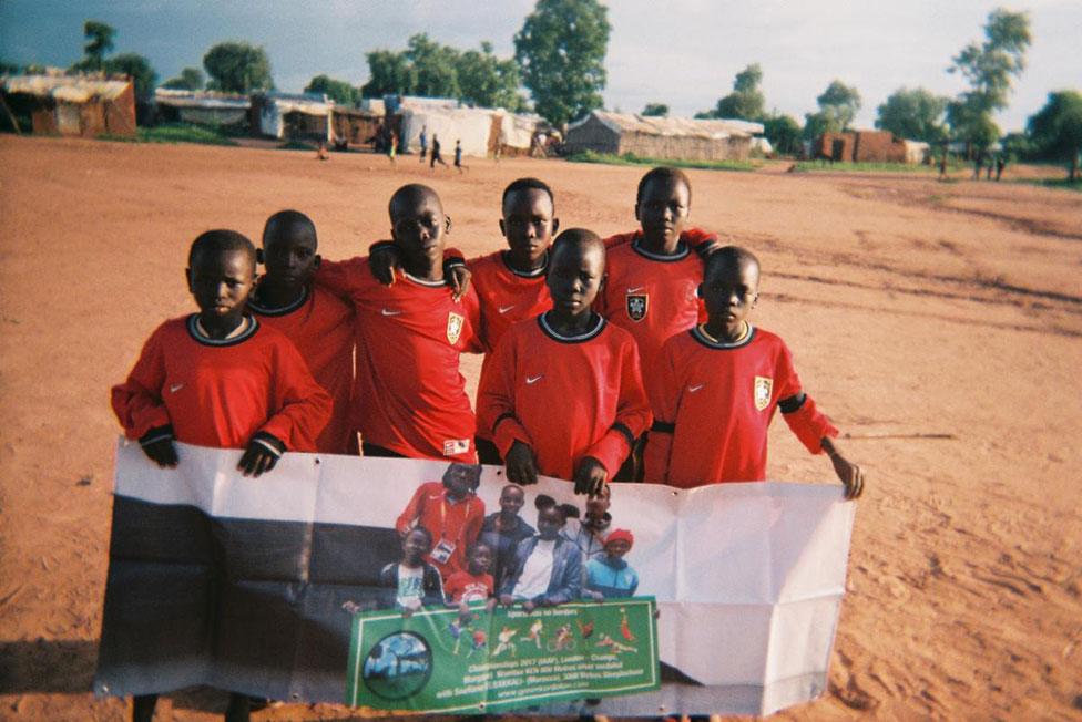 A group of children hold a placard