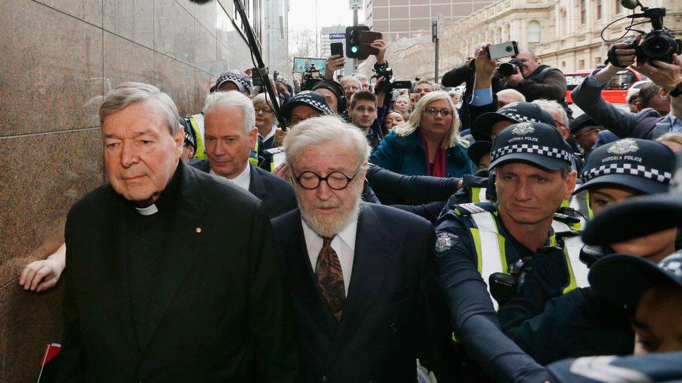 George Pell with his lawyer and a police escort at a court appearance in Melbourne in May 2018