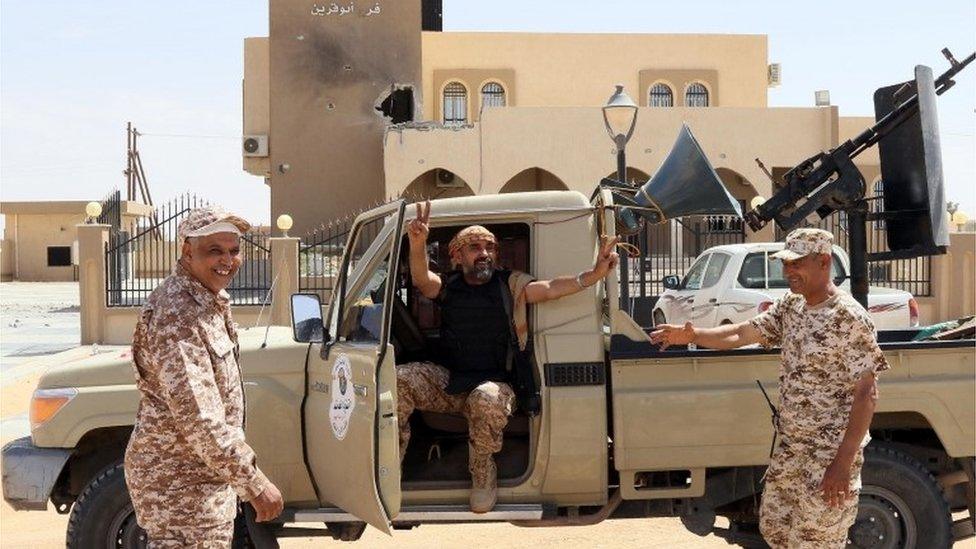 Libyan pro-government forces celebrate on tank after taking back the city of Misrata from IS