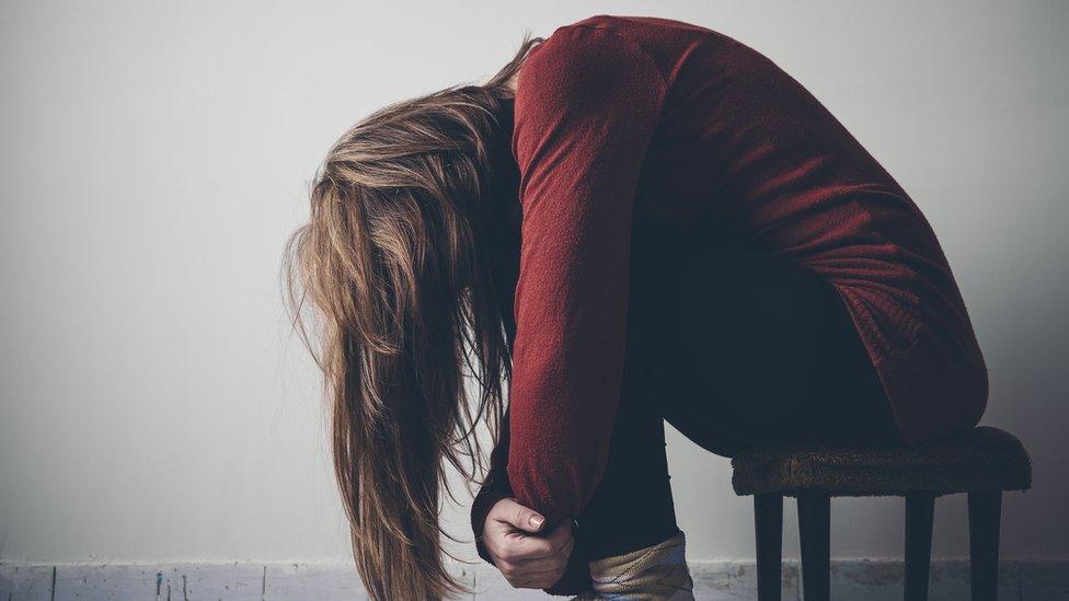 Woman folded up, bent over