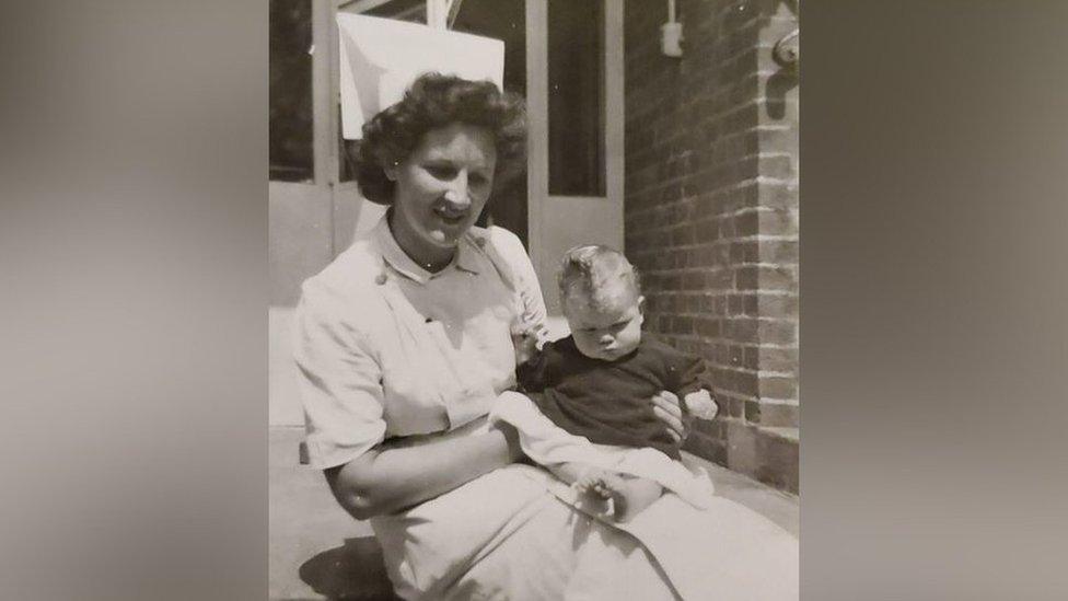 Nurse Marjorie Try (formerly Dodd) holding a baby