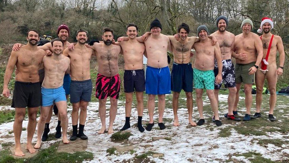 A group of swimmers standing in snowy grass