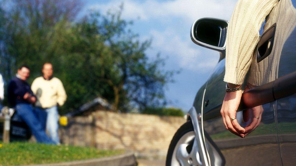 Person with hand hanging out of a car window