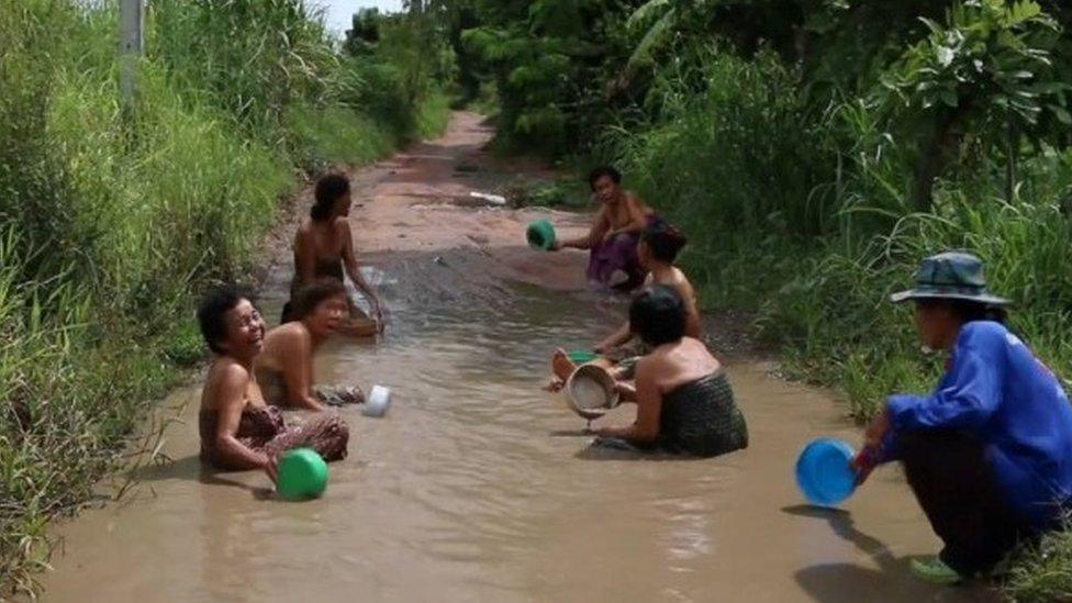 Grannies take bath in potholes