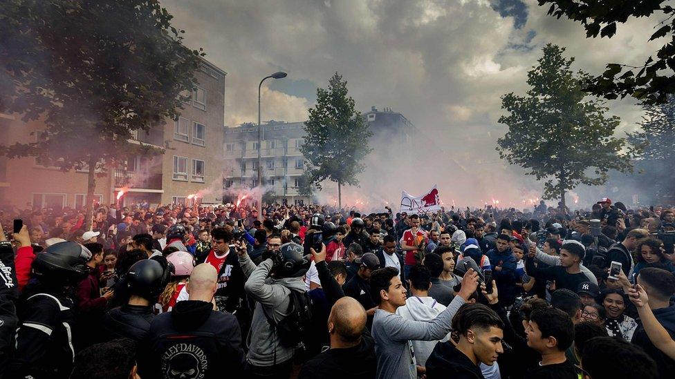 Ajax fans gather outside of the family home of Dutch midfielder Abdelhak Nouri on July 14, 2017 in Amsterdam