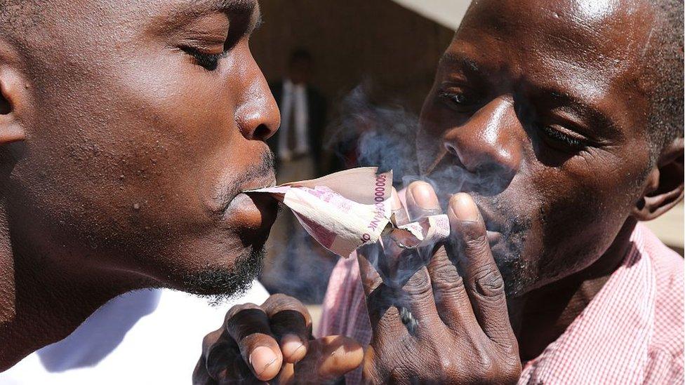 People burn worthless note bearers' cheques during a protest against the introduction of new bond notes and youth unemployement on August, 3, 2016 in Harare, Zimbabwe