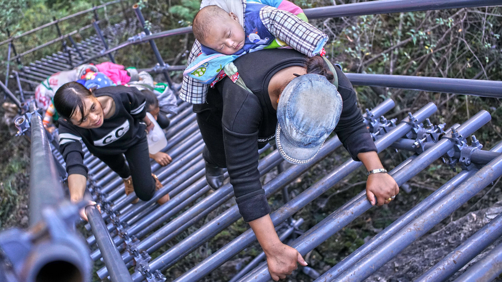 People climb on the newly-built metal ladder with hand railings to Atuler village on a cliff on November 11, 2016 in Zhaojue county, China