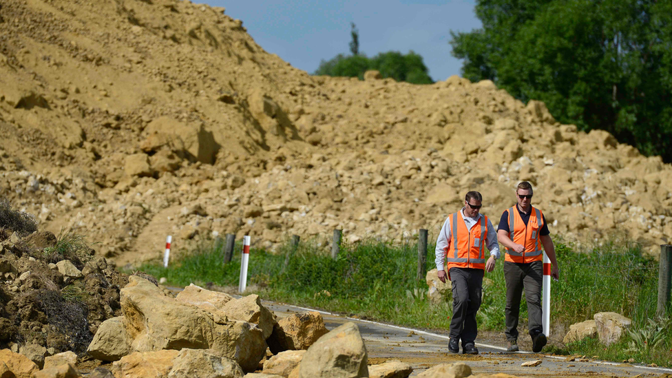 Emergency services officers inspect the damage to Rotherham Road near Waiau town