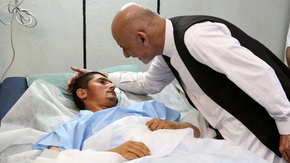 Afghan President Ashraf Ghani meets the survivor of a Taliban attack in hospital