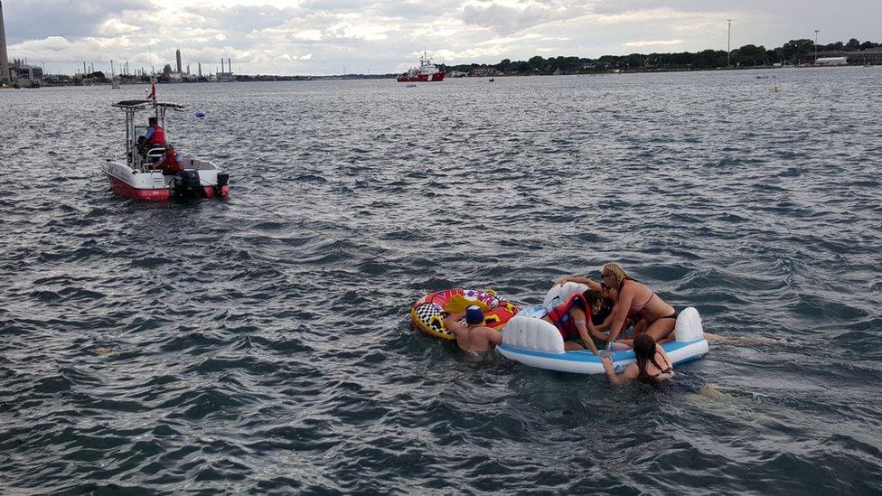 A Canadian Coast Guard ship tows floatation devices used by U.S. partiers