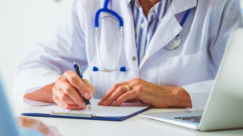 Doctor making notes on a patient