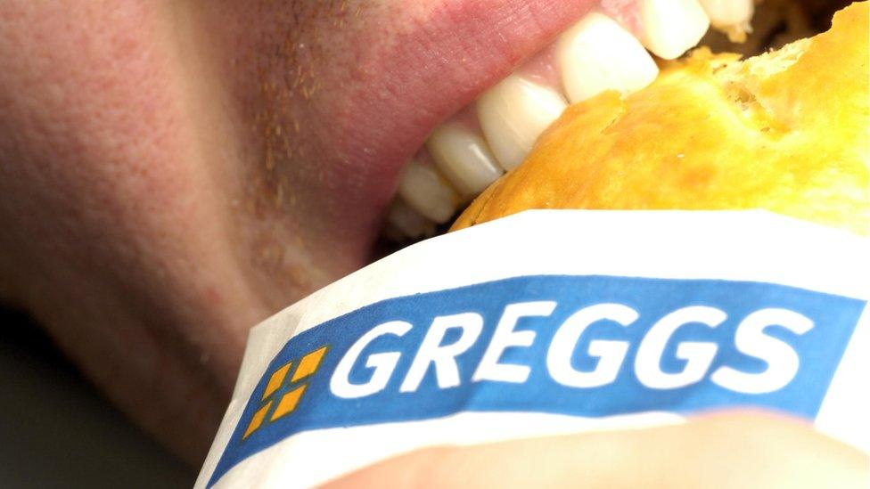 Person eating a Greggs pasty