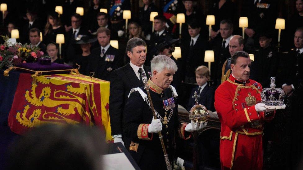 royal staff take crown jewels from the coffin in st george's chapel up to the altar