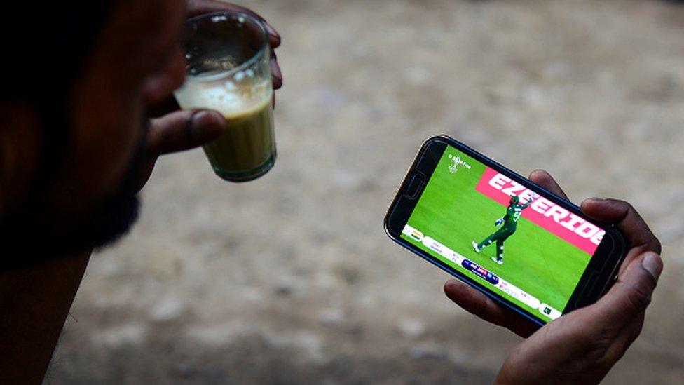 An Indian fan watches a live broadcast of the Cricket World Cup match between India and Pakistan on a mobile phone in Allahabad on June 16, 2019