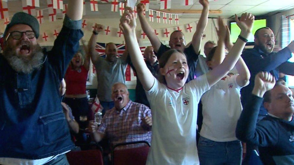 Image of fans celebrating surrounded by England flags