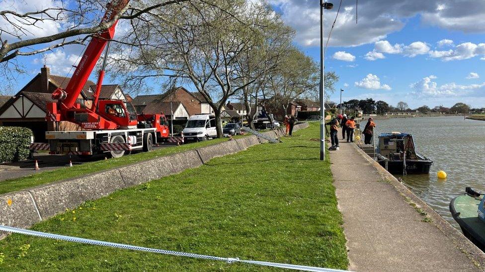 A red crane on the banks of the river Bure to aid in the recovery of a car.