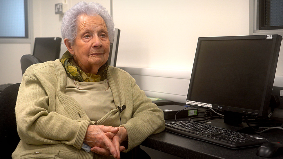 Margaret sitting in beside a computer