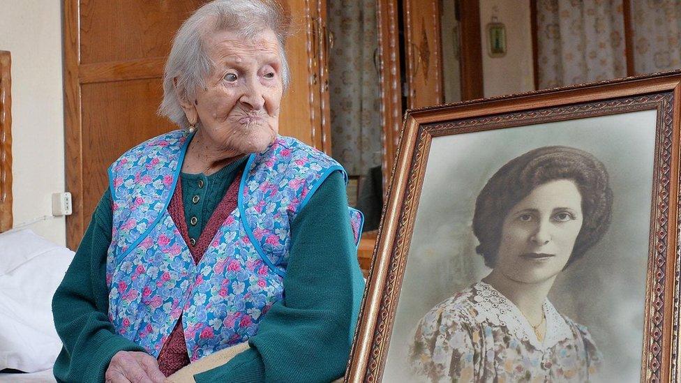 Emma Morano sits in her apartment next to a picture depicting her where she was young in Verbania, northern Italy, 13 May 2016