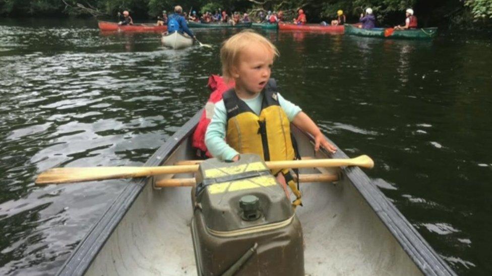 Kiara wearing a life-jacket in a canoe on the water