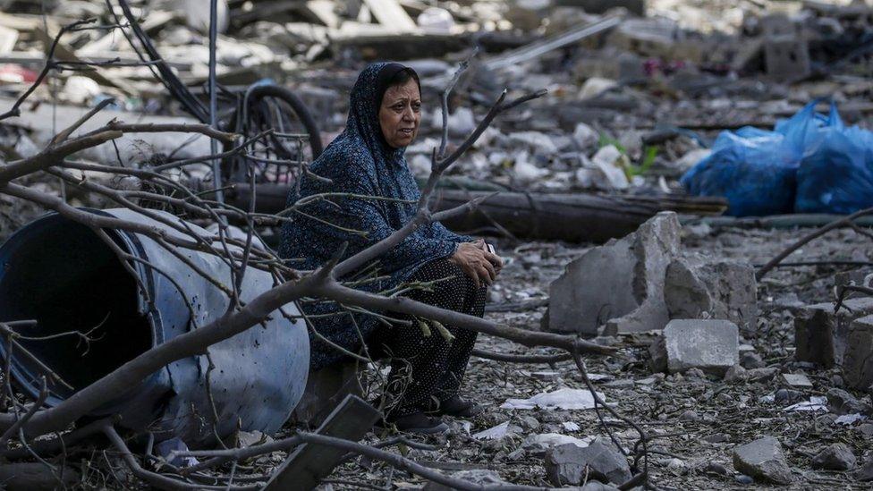 A resident of Gaza City's Rimal neighbourhood sits down on debris left after a night of Israeli air strikes (10 October 2023)