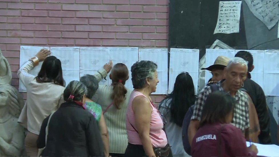 Voters look at lists outside a polling station