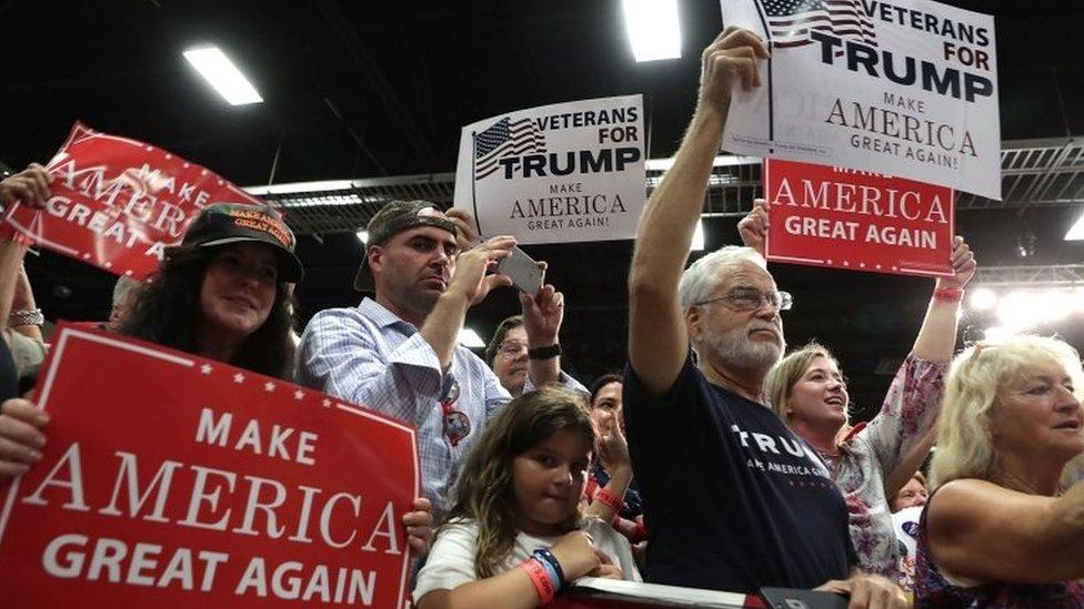 Supporters hold up signs during a campaign rally of Republican presidential nominee Donald Trump in Fredericksburg, Virginia.