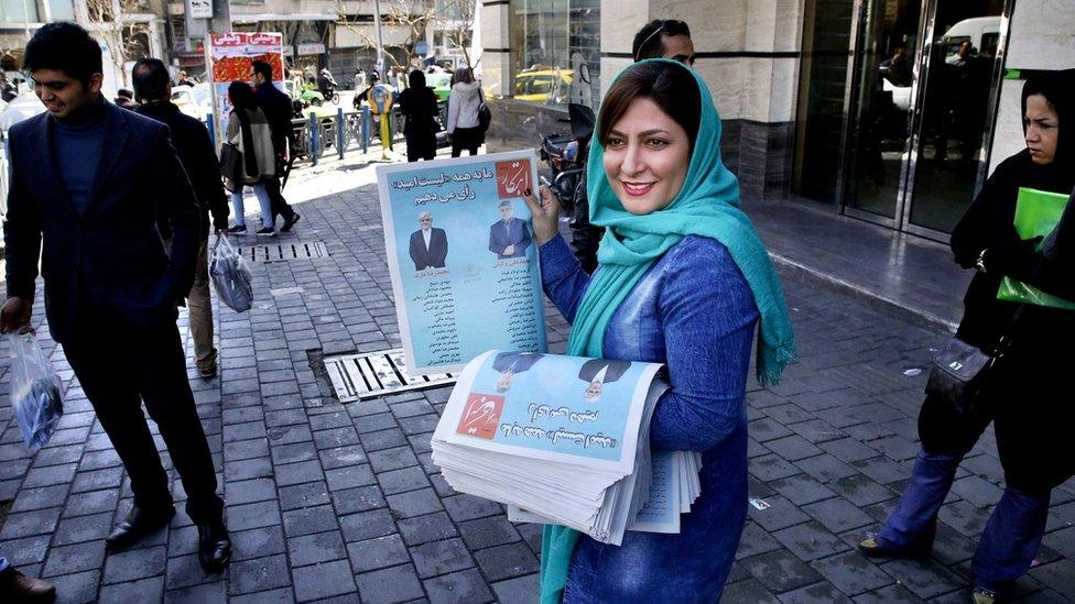 A campaign worker distributes electoral leaflets of reformist candidates in Tehran, Iran (24 February 2016)