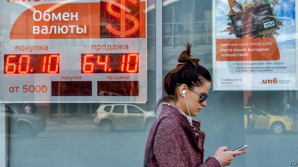 woman walks past a currency exchange office in Moscow