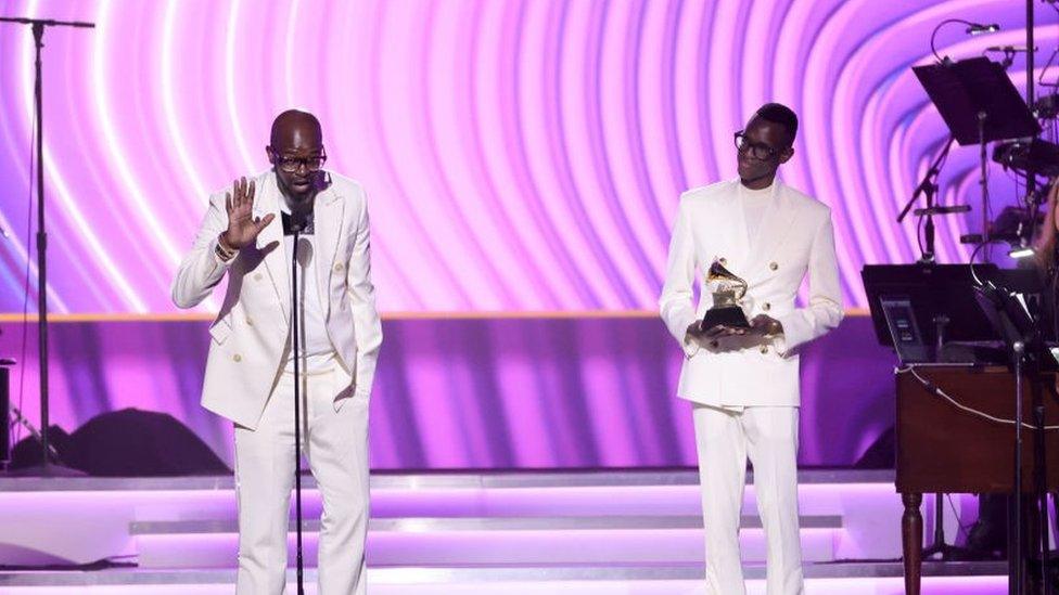 Black Coffee accepting his Grammy award alongside his son