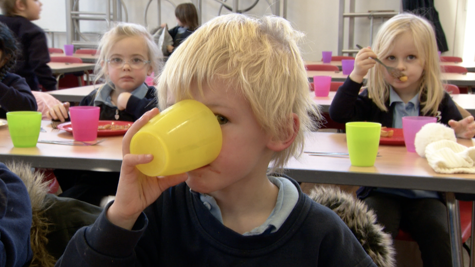 Child drinking water from a yellow plastic glass at a Bridgwater school