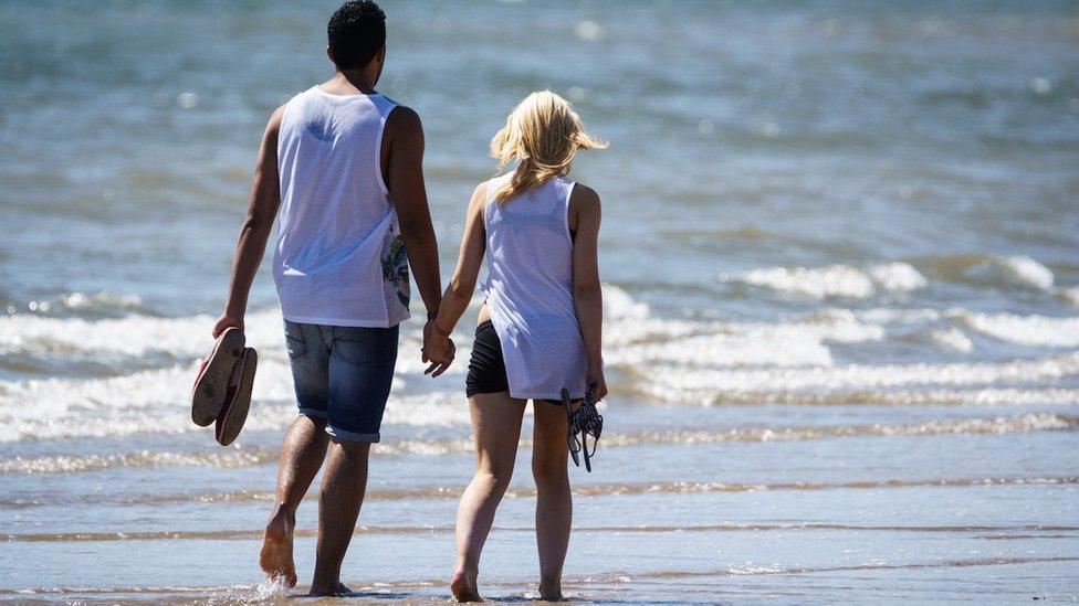 Jason Dale captured this image of a couple walking across the beach at Swansea.