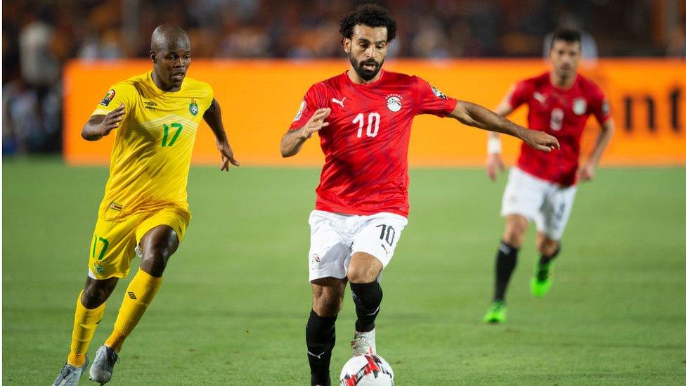 Salah fighting off a Zimbabwe player