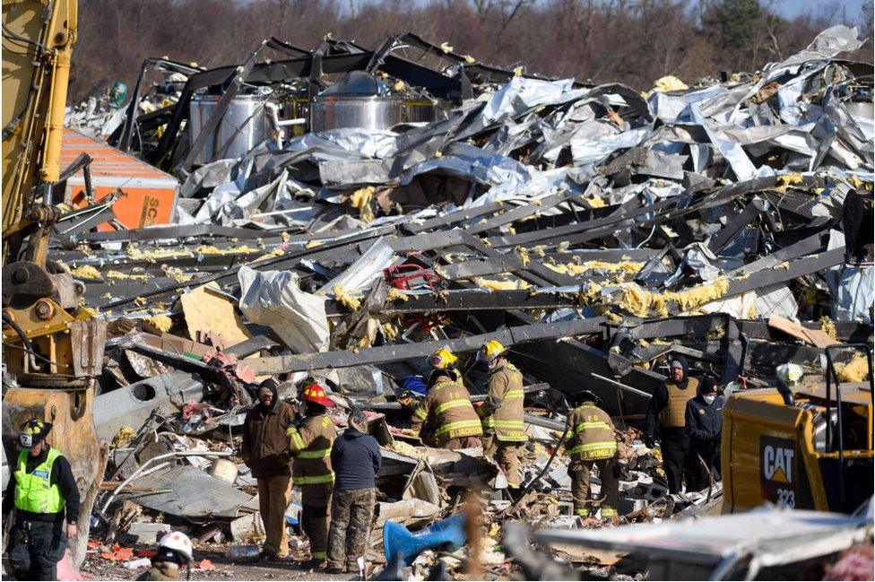 Workers search the razed Mayfield Consumer Products Candle Factory for survivors